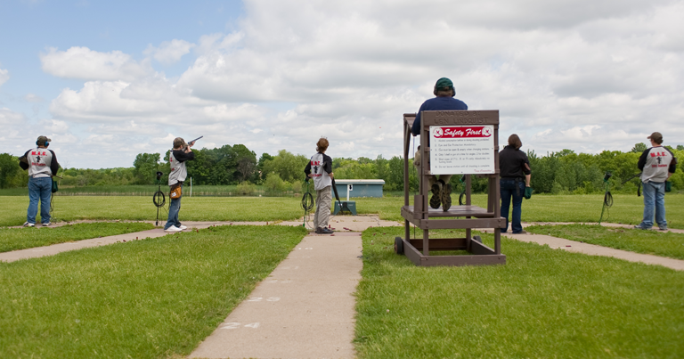 A group of people standing on a shooting range.